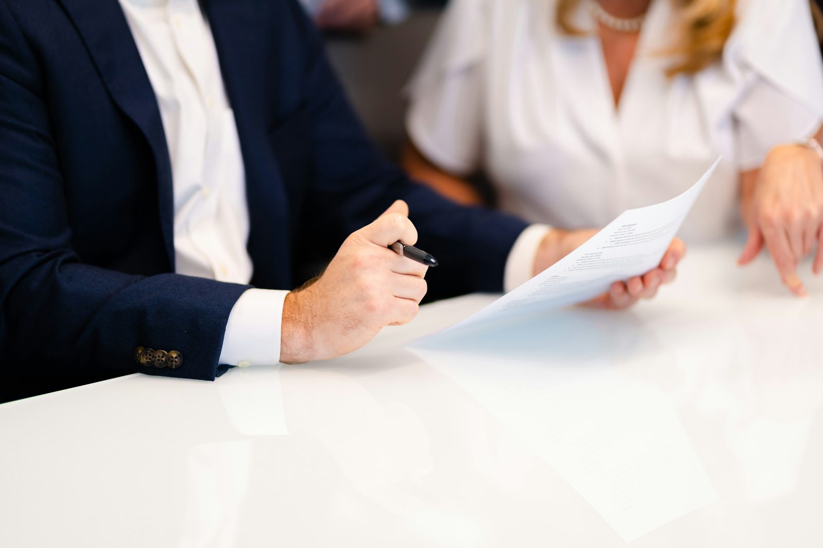 An immigration attorney going through adjustment of status paperwork with a couple at a conference table