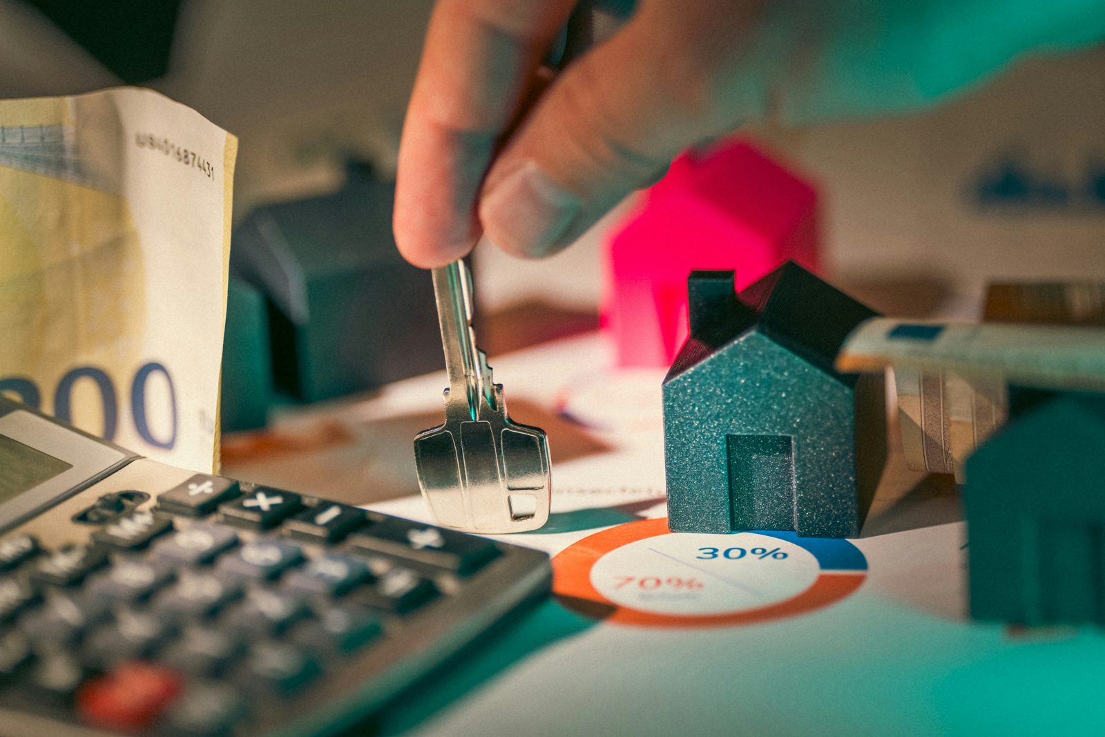 Model houses, banknotes and a calculator on a desk, the arithmetic behind an investment visa
