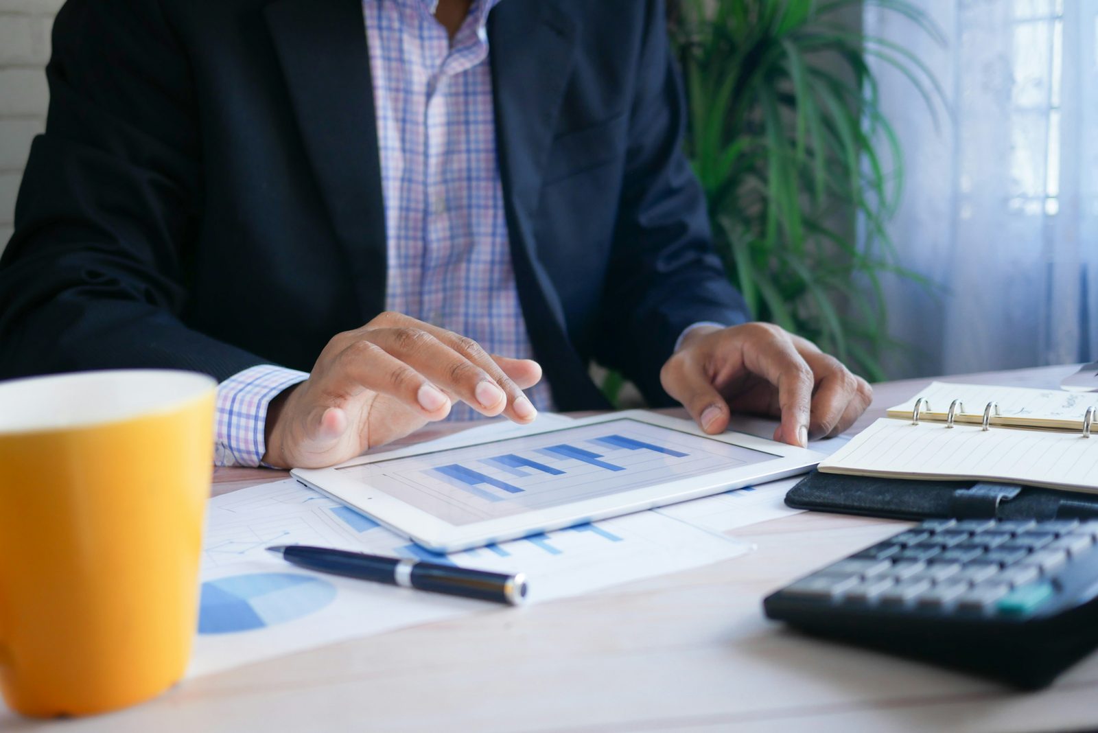 An investor going through business figures on a tablet, the plan an E-2 or EB-5 petition rests on