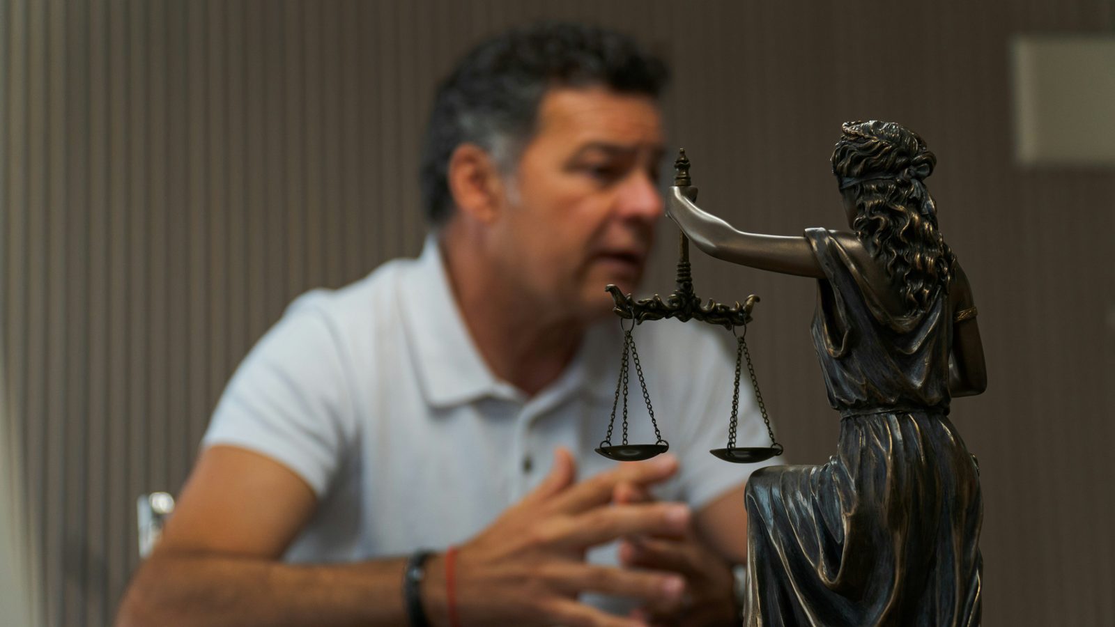 A client explaining his case at a military parole in place consultation, a figure of Justice in the foreground