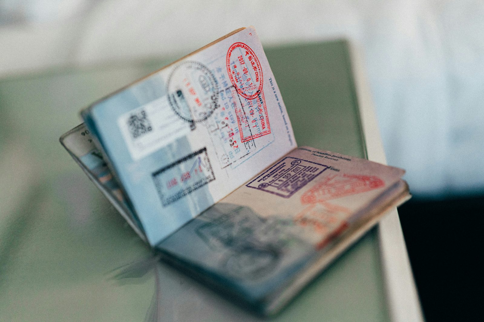 An open passport filled with visa and entry stamps, the record a work visa lawyer works from